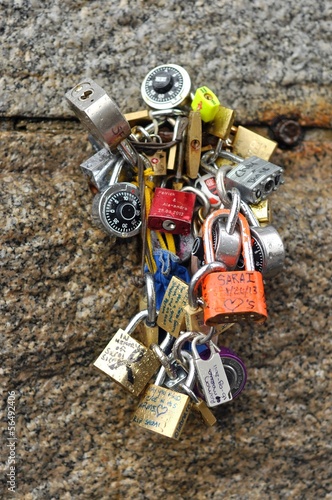 Many love padlocks tied to a wall