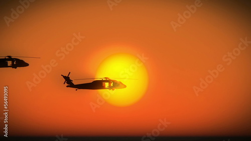 Helicopters flying in formation over sunset