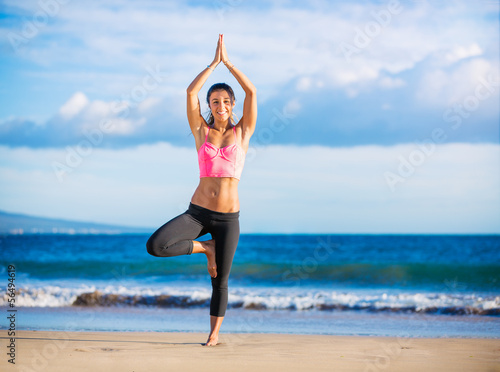 Woman practicing yoga at sunset
