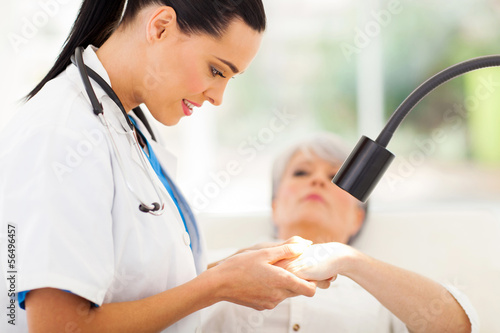 dermatologist examining senior woman's skin photo