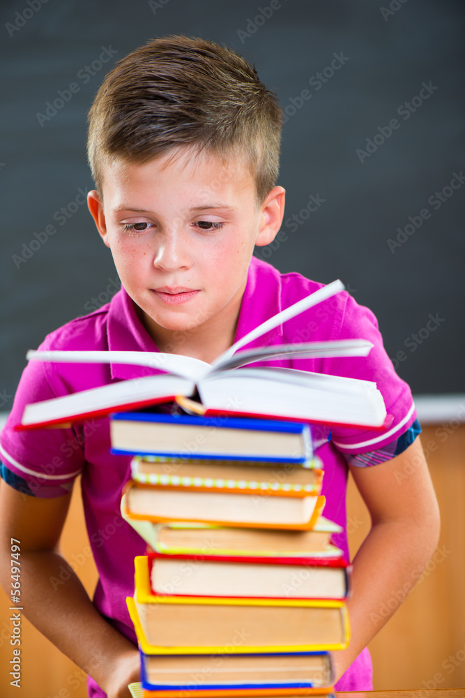 Adorable schoolboy with stack of books Adorable schoolboy with stack of books