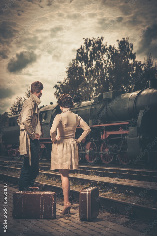 Beautiful couple with suitcases on train station Beautiful couple with suitcases on train station