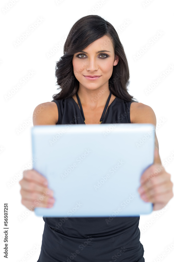 Peaceful elegant brown haired model holding tablet in front of h Peaceful elegant brown haired model holding tablet in front of h
