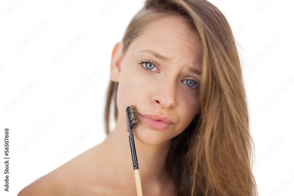 Puzzled brunette model holding a brush Puzzled brunette model holding a brush