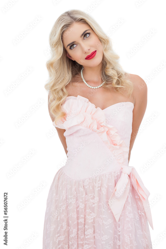 Content blonde model in pink dress posing looking away Content blonde model in pink dress posing looking away
