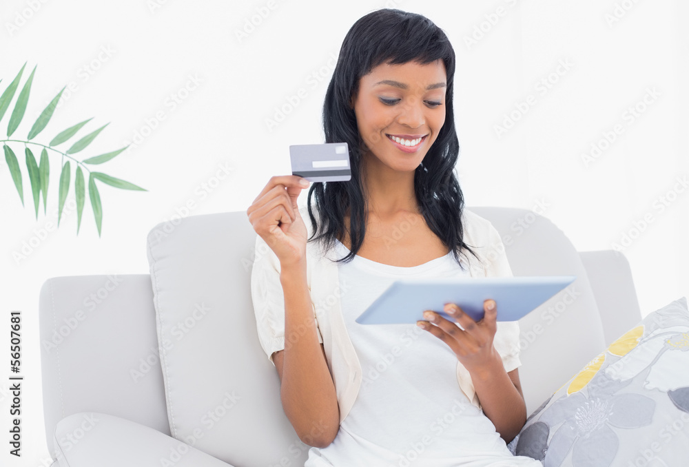 Lovely black haired woman buying online with her tablet pc Lovely black haired woman buying online with her tablet pc