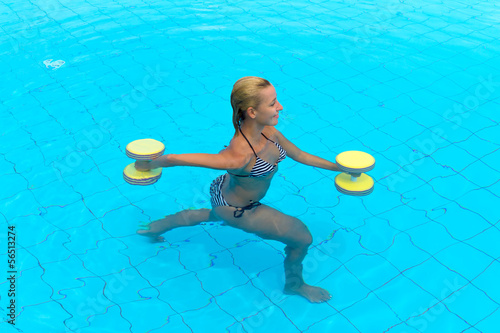 Woman is engaged aqua aerobics in water photo