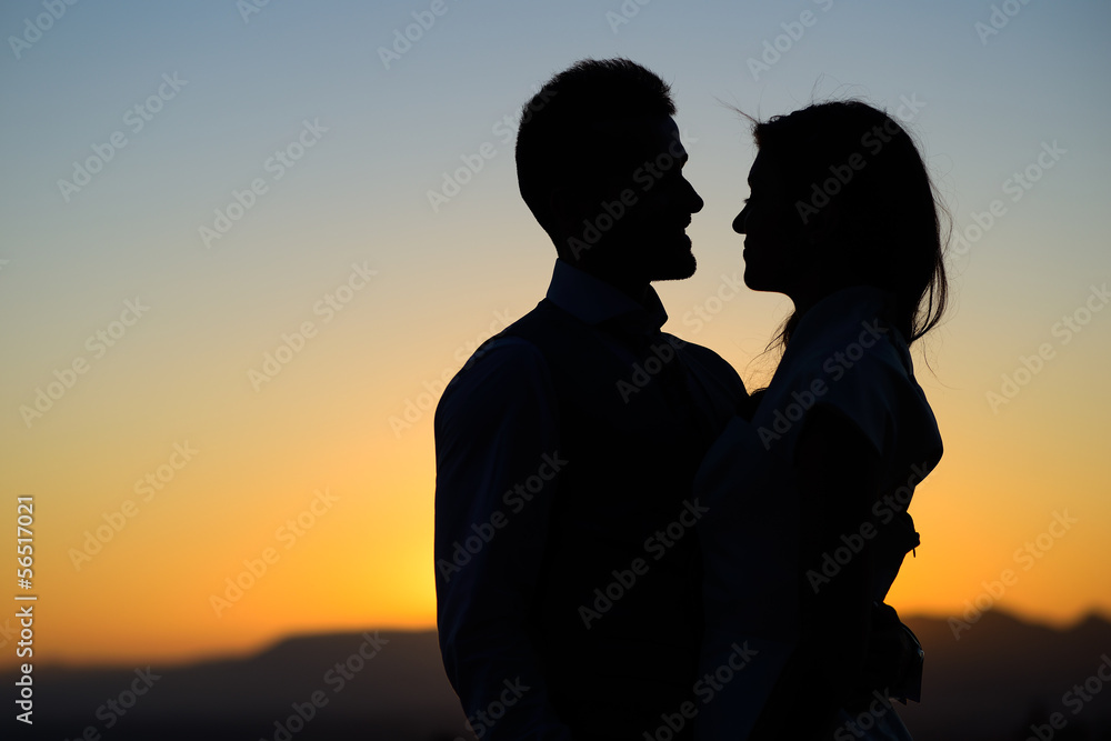 silhouette of bride and groom on Sunset background