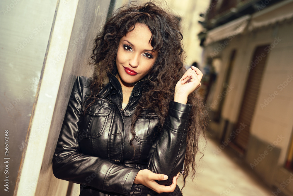 Attractive black woman in urban background wearing leather jacke