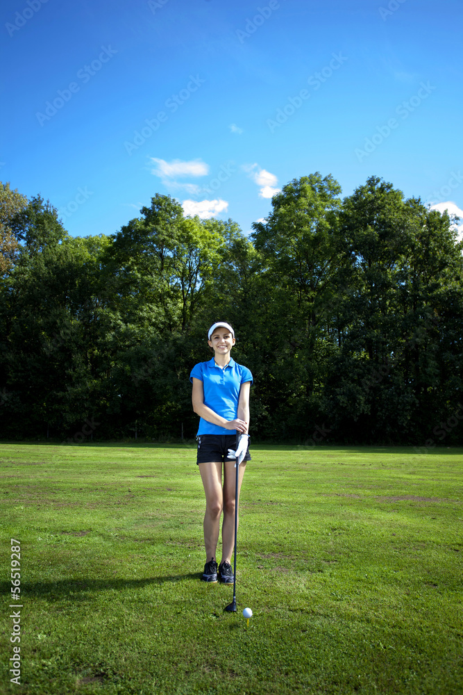 Pretty girl playing golf on grass