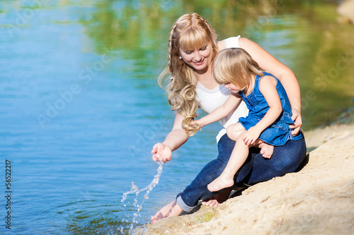 happy young family spending time outdoor on a lake