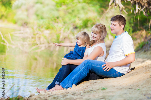 happy young family spending time outdoor on a lake
