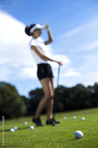 Girl playing golf on grass in summer 