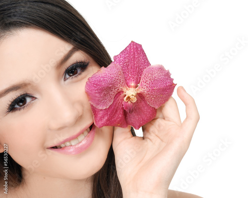 portrait of girl holding pink orchid flower in her hands