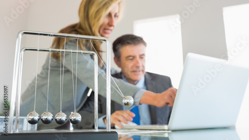 Businesswoman explaining something on the computer to a concentr