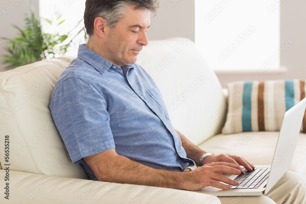 Thinking man sitting on sofa using laptop Thinking man sitting on sofa using laptop