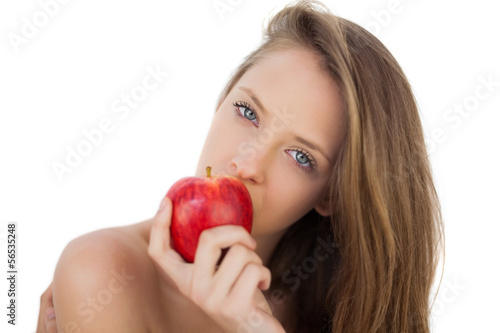 Pensive brunette model eating an apple