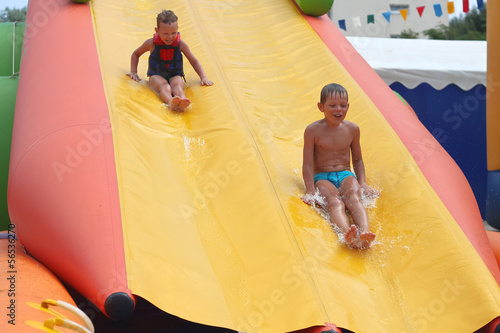 Enthusiastic kids on slide in the water park