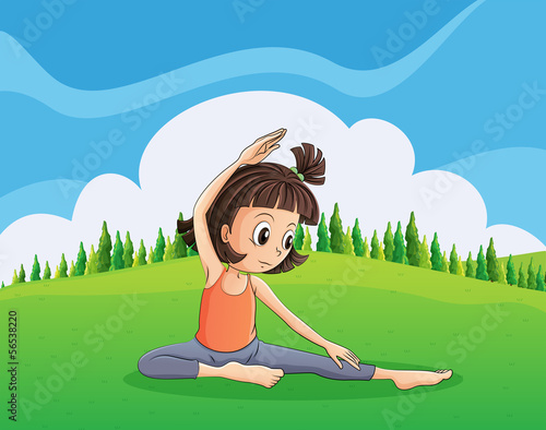 A young girl doing yoga at the hilltop