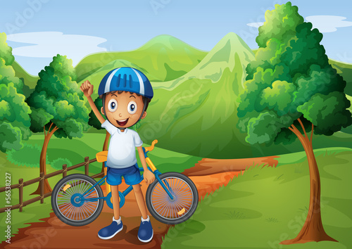 A boy standing in the pathway with his bike