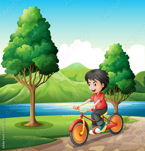 A boy biking at the riverbank