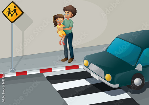A father carrying his daughter at the pedestrian lane