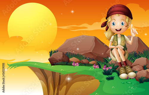 A young girl near the cliff siting above the rock