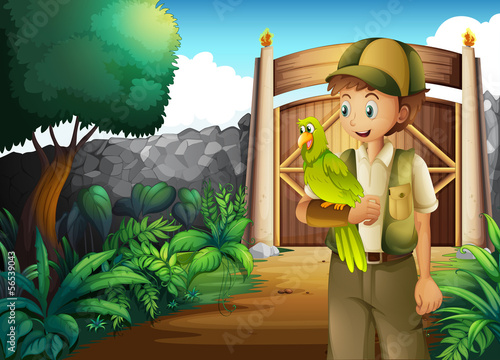 A boy inside the gate with his parrot