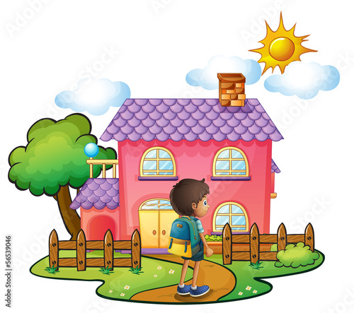 A boy in front of the big pink house
