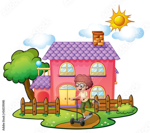 A boy playing in front of the big pink house