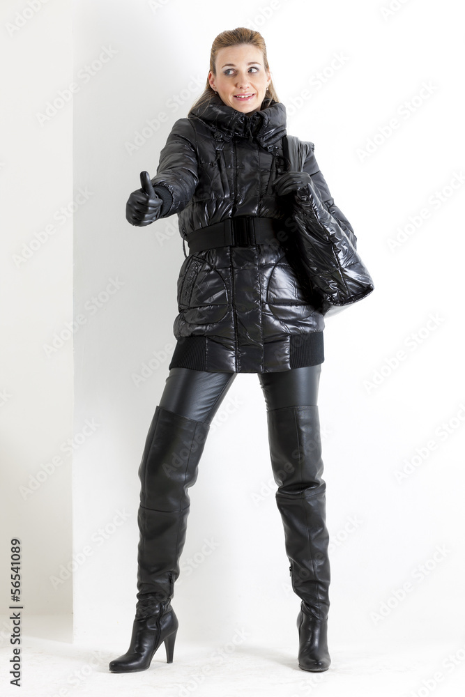 standing woman wearing black clothes holding a handbag standing woman wearing black clothes holding a handbag