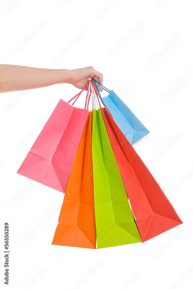 Woman hand holding several shopping bags isolated on white.