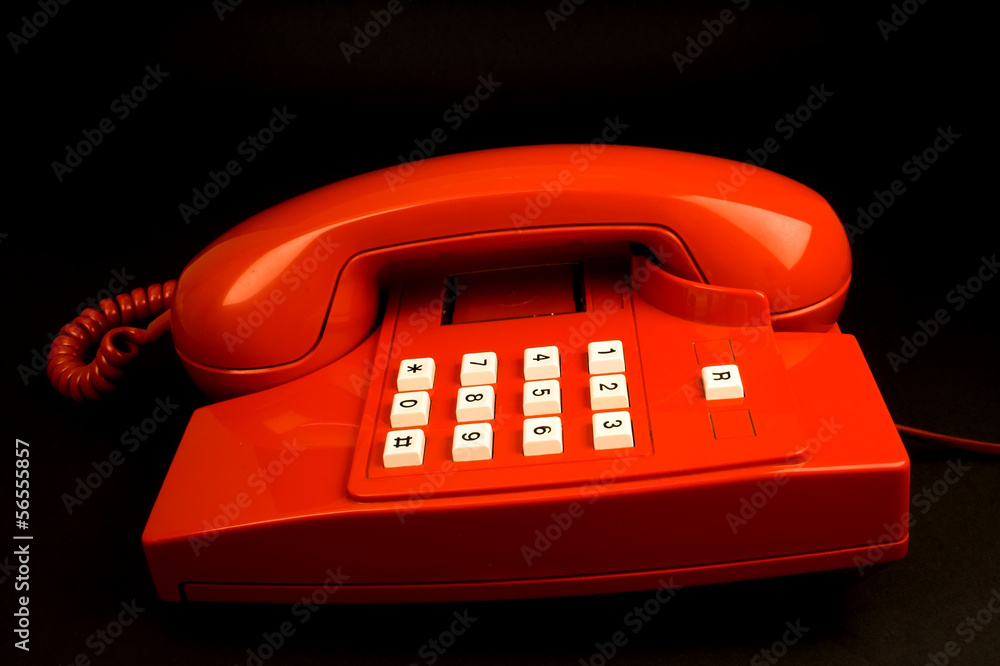 Red telephone on a black background Red telephone on a black background