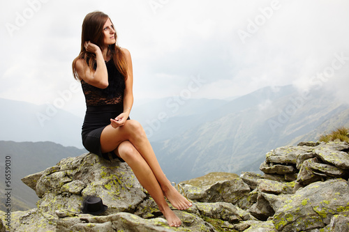 Elegant woman in dress sitting on the rocks © Xalanx