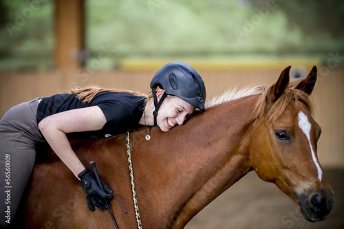 Junge Frau umarmt ihr Pferd und ist glücklich