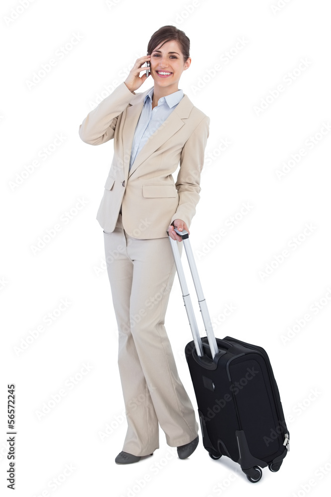 Businesswoman posing with suitcase and phone Businesswoman posing with suitcase and phone