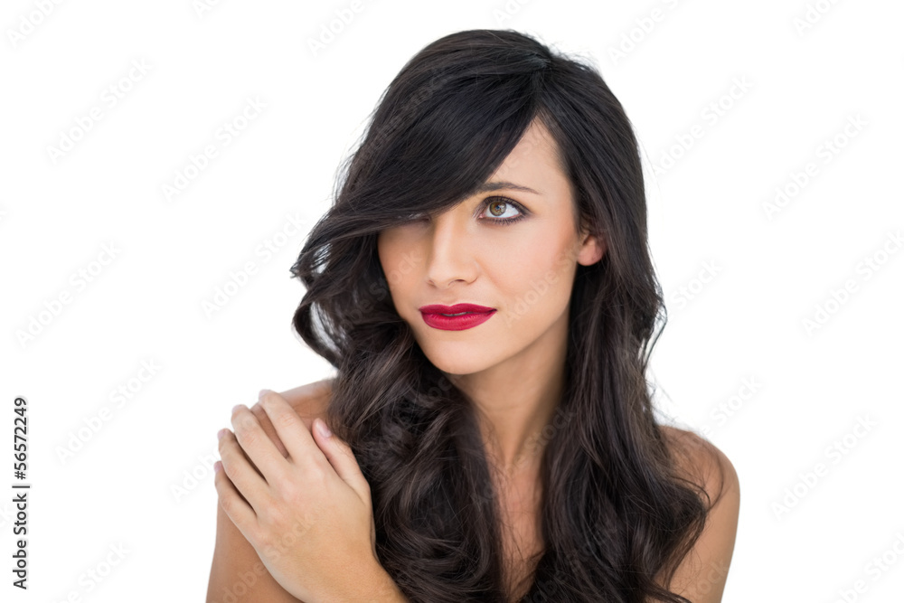 Glamorous brunette posing with hand on her shoulder looking away Glamorous brunette posing with hand on her shoulder looking away