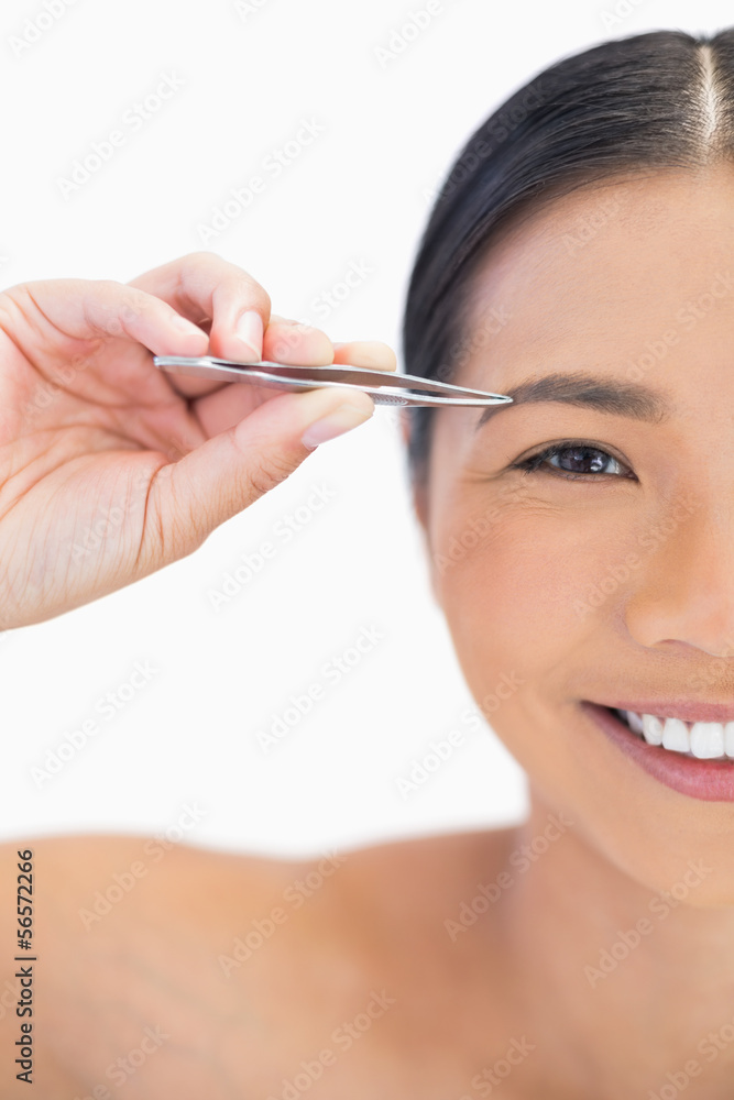 Half face of smiling natural woman using tweezers Half face of smiling natural woman using tweezers