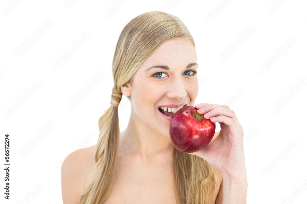 Pleased young blonde woman eating a red apple Pleased young blonde woman eating a red apple