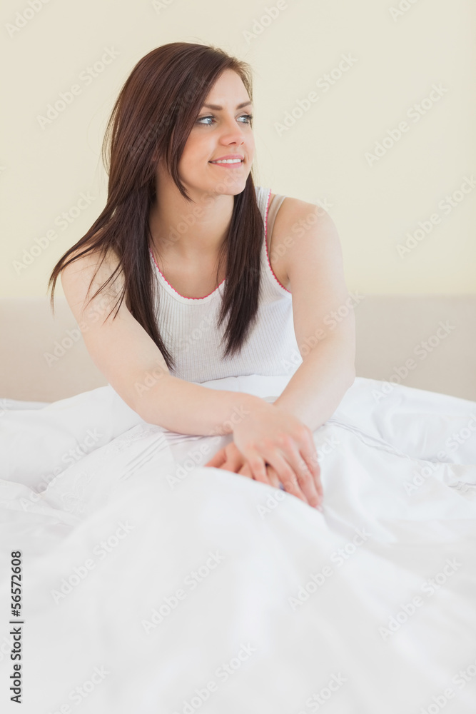 Awakened girl looking away and sitting in her bed Awakened girl looking away and sitting in her bed