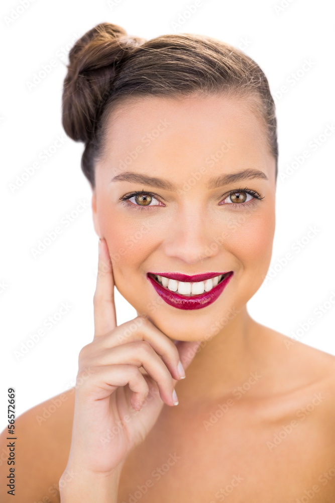 Pretty woman with red lips touching her cheek smiling at camera Pretty woman with red lips touching her cheek smiling at camera