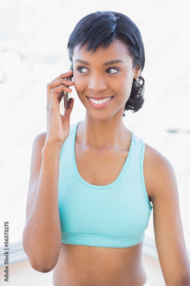 Happy fit woman calling someone with her mobile phone Happy fit woman calling someone with her mobile phone
