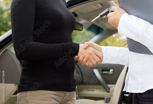 Women shaking hands on a car purchase
