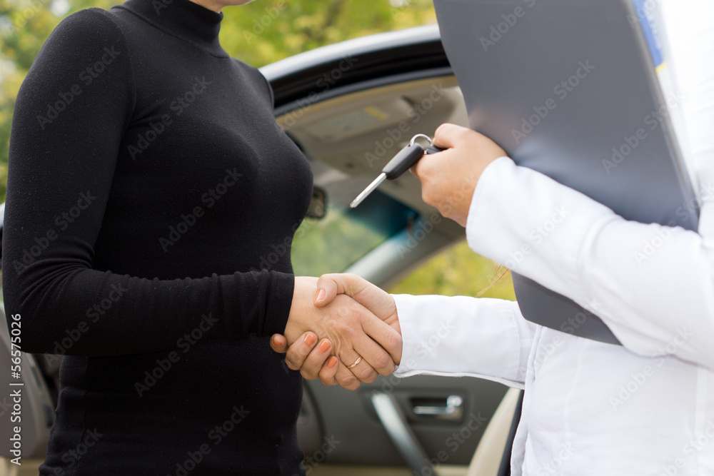 Shaking hands on the sale of a new car Shaking hands on the sale of a new car