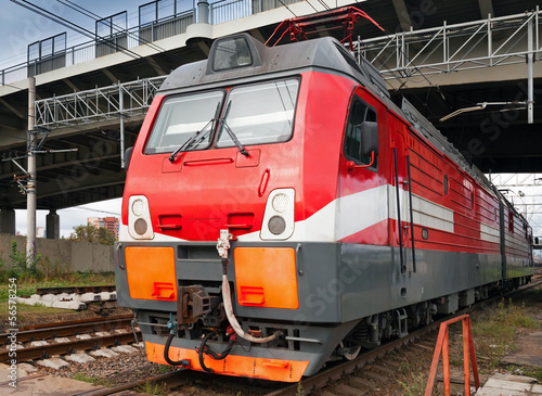 Closeup photo of modern red locomotive on railway