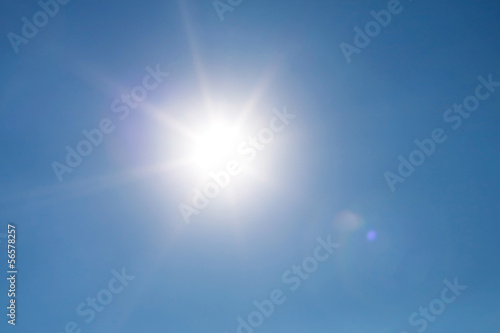 Real photo lens glow effect of sun on clear blue sky