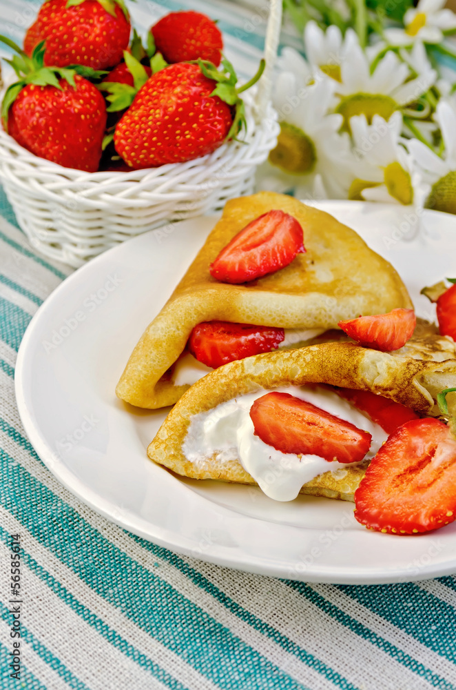 Pancakes with strawberries and basket with berries on a napkin Pancakes with strawberries and basket with berries on a napkin