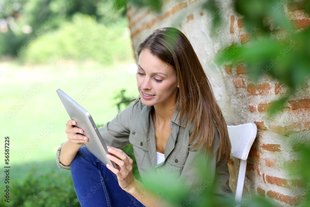 Girl connected on internet in country home garden Girl connected on internet in country home garden