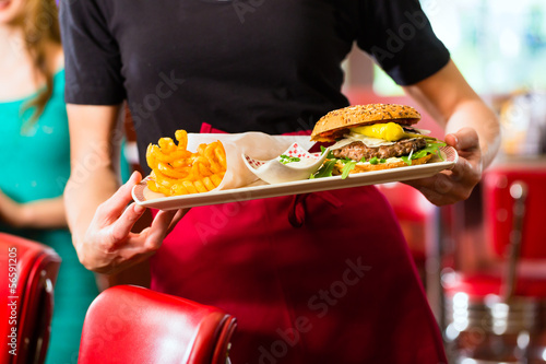 Waitress serving in American diner or restaurant photo