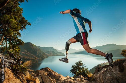 Hombre lisiado saltando en la montaña